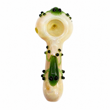 A hand-blown glass smoking pipe with a mushroom-shaped bowl and stem, decorated with green glass vines, black seed beads, and a green frog figure at the base, shown on a plain white background.

