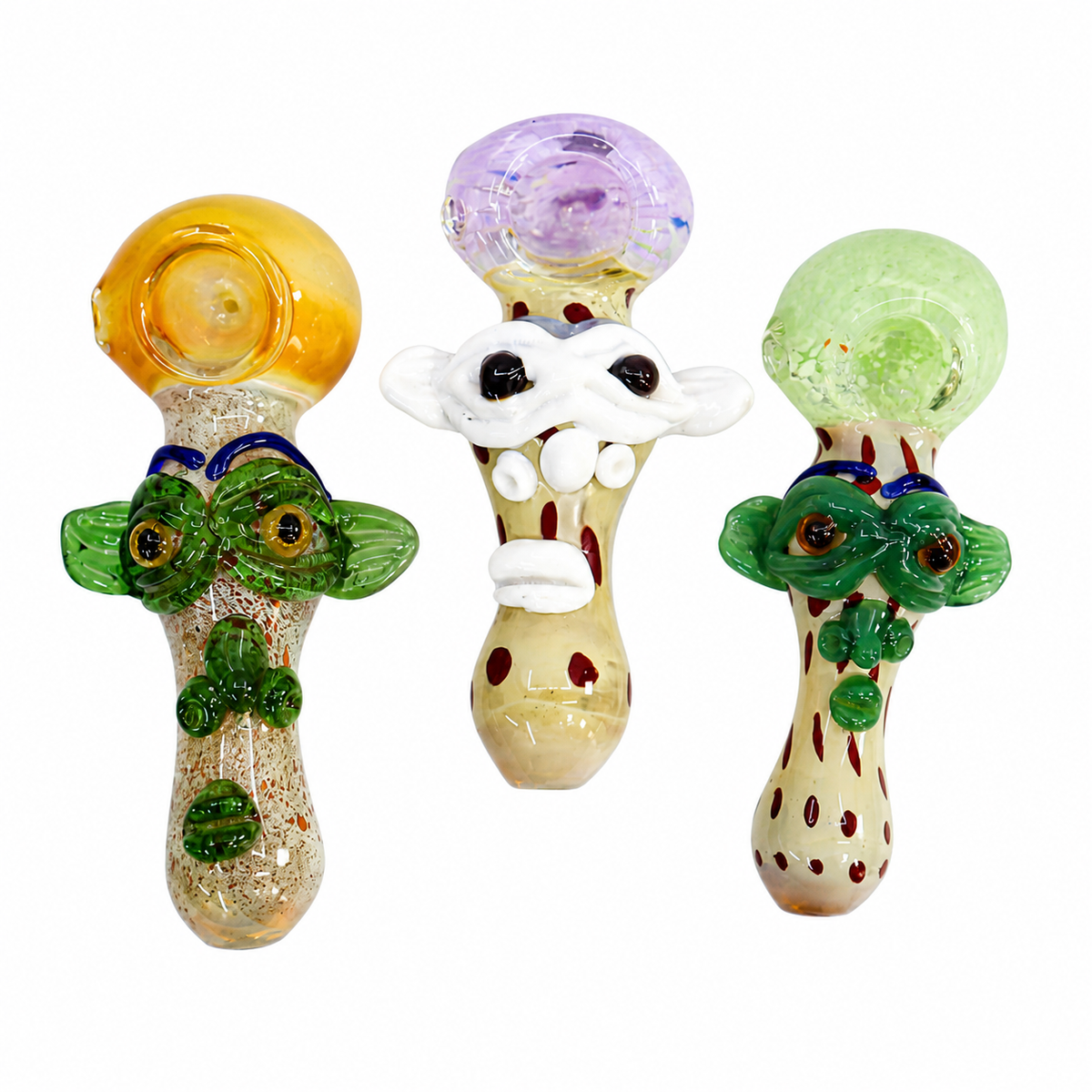 Three hand-blown glass novelty pipes with whimsical cartoon faces, displayed side-by-side on a solid white background.

