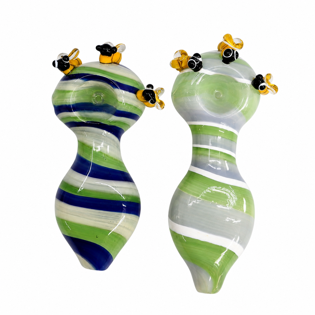 Two handmade glass sculptures shaped like female breasts, decorated with green, blue, and white stripes and small yellow-and-black bumblebee figures on top, set against a plain white background.

