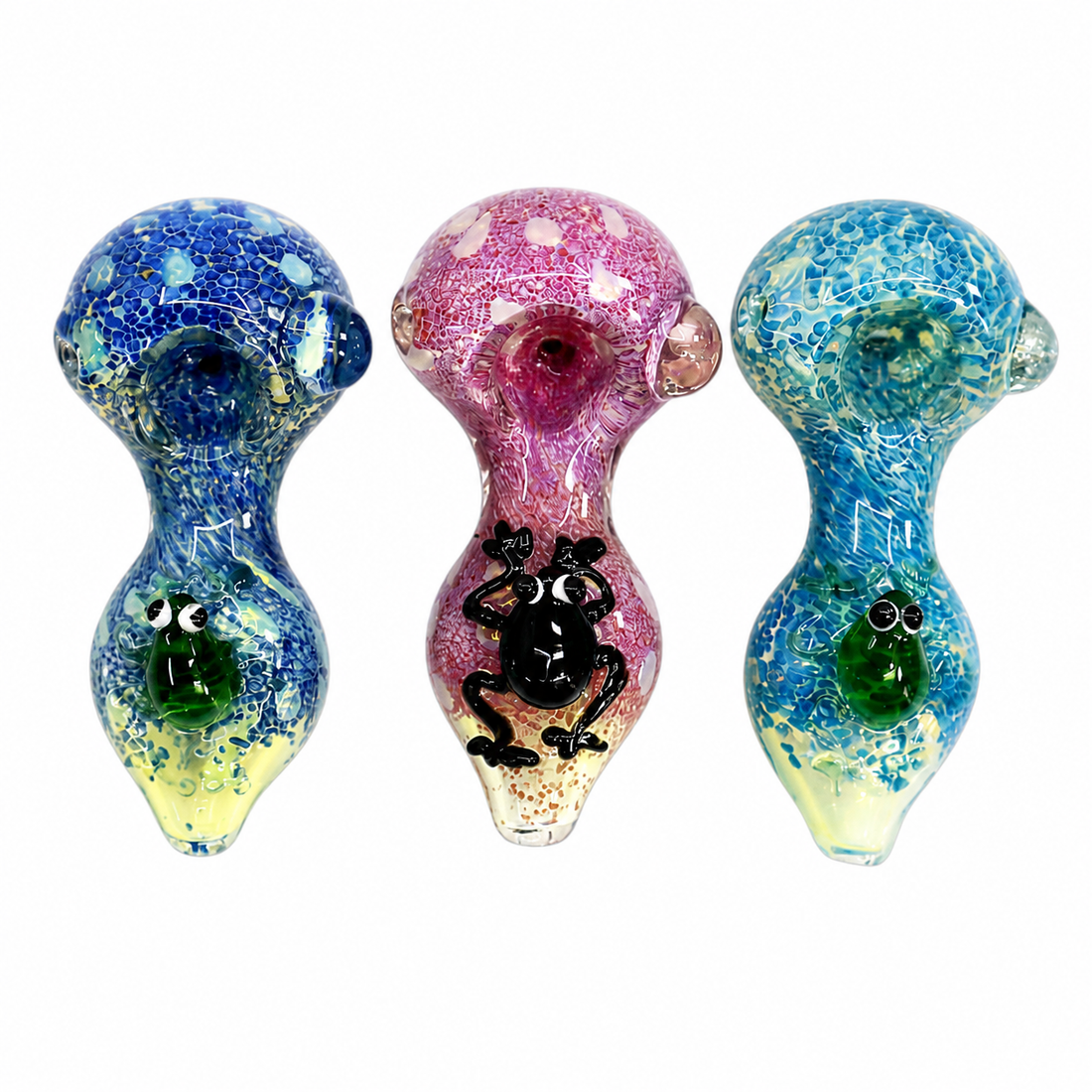 Three handmade glass water pipes with unique designs and colors, displayed side-by-side on a plain white background. The left pipe is blue and yellow with a green frog face.