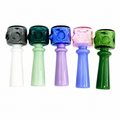 Five glass water pipes in different colors (black, green, blue, pink, and dark green) arranged in a row against a plain white background.

