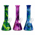 Three colorful glass beakers with white stoppers on a white background