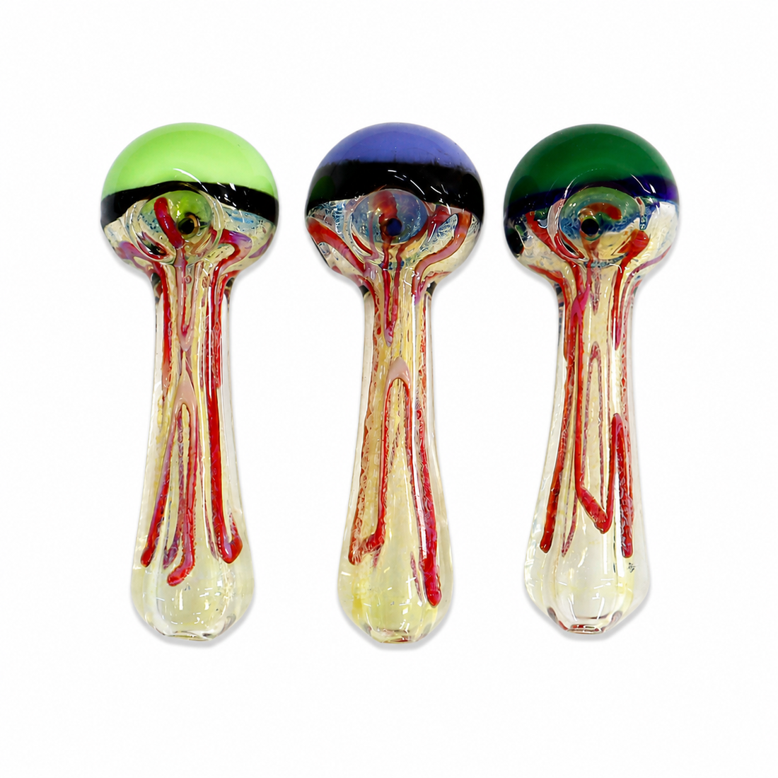 Three hand-blown glass water pipes with mushroom-shaped heads, displayed side-by-side on a white background. Each pipe features a unique colored top dome (light green, black and blue, dark green) with red and yellow glass veins dripping down into a clear glass base.

